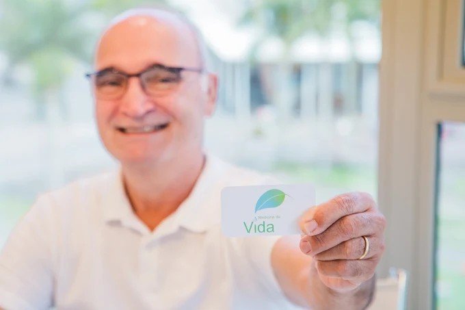 Paciente segurando o cartão da Medicina da Vida